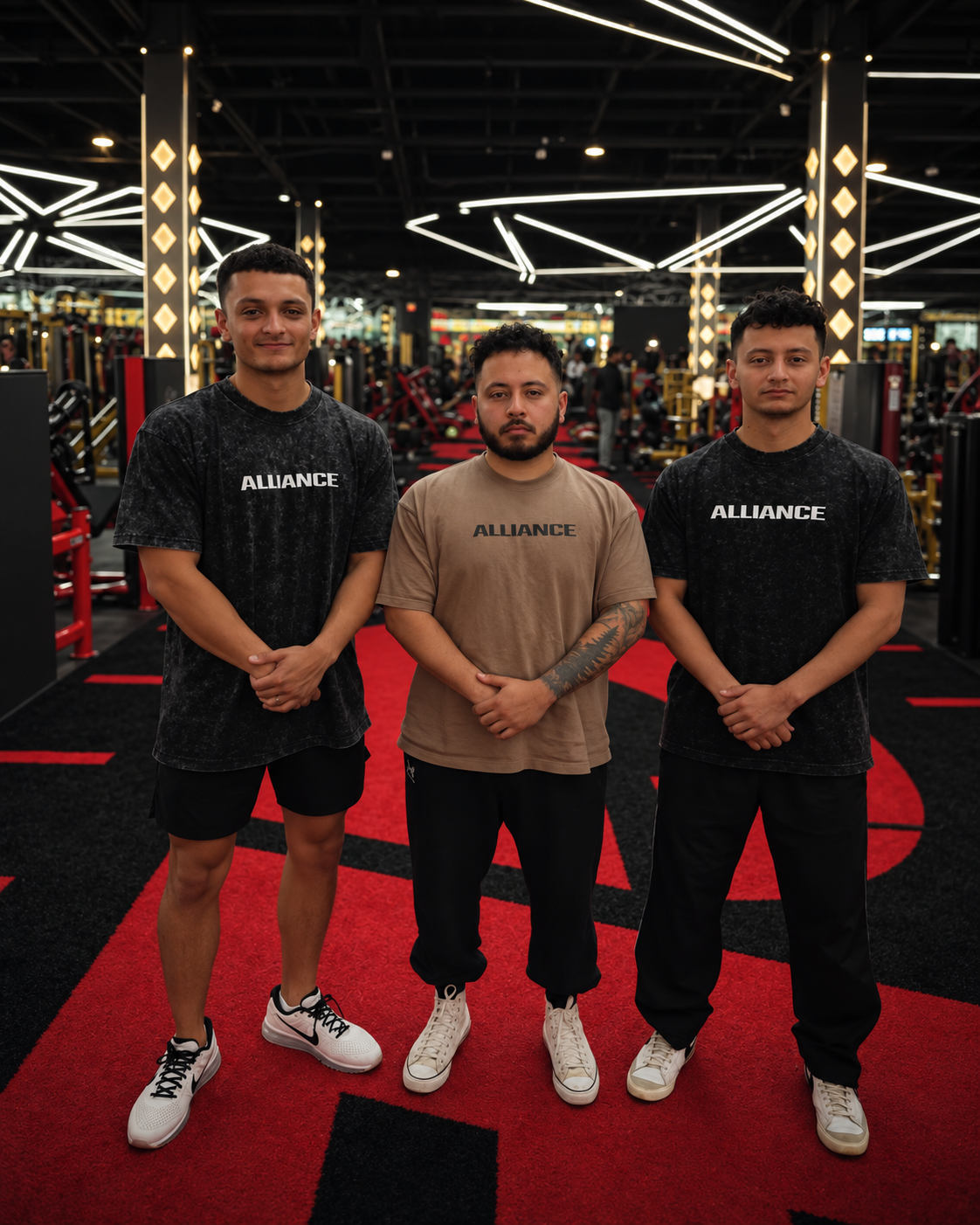 The three ALLIANCE brothers standing together in the gym wearing ALLIANCE shirts.